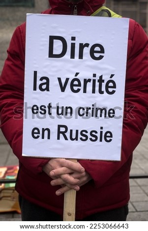 Closeup of people pprotesting with placard in french : dire la verite en russie est un crime, in english ; telling the truth in russia is it a crime