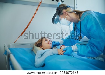 Friendly woman doctor taking care and playing with little girl.