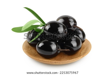 Black olives with leaves in wooden bowl isolated on a white background with full depth of field.