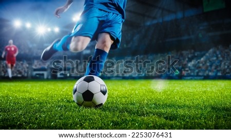 Football World Championship: Soccer Player Runs to Kick the Ball. Ball on the Grass Field of Arena, Full Stadium of Crowd Cheers. International Tournament. Cinematic Shot Captures Victory. Royalty-Free Stock Photo #2253076431