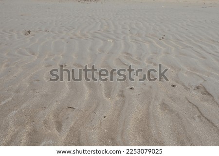 Wavy beach sand texture during daytime, summer travel background
