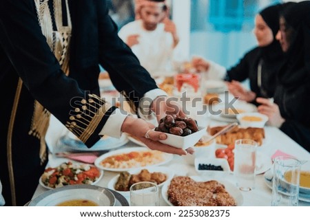  Muslim family having Iftar dinner drinking water to break feast. Eating traditional food during Ramadan feasting month at home. The Islamic Halal Eating and Drinking in modern home  Royalty-Free Stock Photo #2253082375