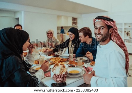  Muslim family having Iftar dinner drinking water to break feast. Eating traditional food during Ramadan feasting month at home. The Islamic Halal Eating and Drinking in modern home  Royalty-Free Stock Photo #2253082433