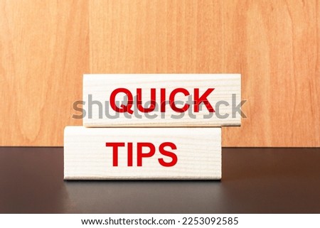 Two wooden blocks with the text QUICK TIPS on a light wooden background