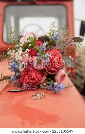 beautiful wedding bouquet with peonies and wedding rings 