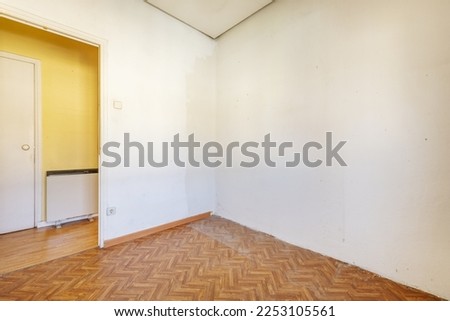 Empty living room with wood-like sintasol floors and electric heat storage radiators