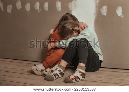 two little sister girls hugged and crying in the attic of the house, they are scared. domestic violence and a dysfunctional family with underage children Royalty-Free Stock Photo #2253113589