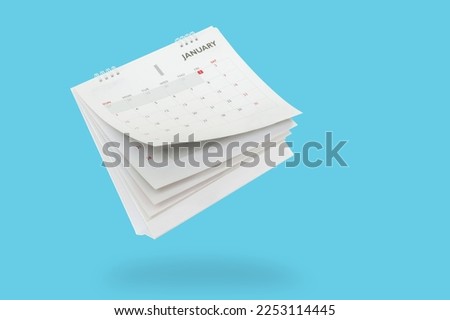 White paper desk calendar flipping page isolated on blue background Royalty-Free Stock Photo #2253114445