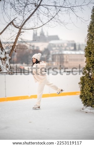 Beautiful girl having fun while skating at ice rink on Prague castle background, Czech republic, Europe. High quality photo