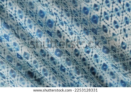 Blue and white wavy textile pattern. Fabric with geometric ornament as background.