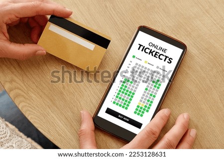 Close-up photo of female hands with credit card making mobile payment for event cinema tickets. Online show theater tickets booking.