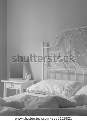 White cozy bedroom daylight, calmness refreshment background, snow white clean sleeping room, nightstand with clock and mirror