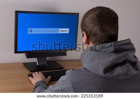 back view of young man searching something in internet