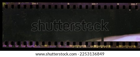 underexposed 35mm film strip on black background with smear marks, scratches and dust. Royalty-Free Stock Photo #2253136849