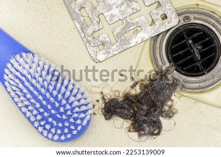 Residue of hair, soap scum, and dirt collected from a shower drain, The image could also be used to showcase the effectiveness of a cleaning product or tool Royalty-Free Stock Photo #2253139009