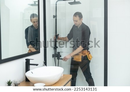 Plumber installing a shower cabin in bathroom Royalty-Free Stock Photo #2253143131