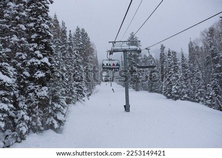 People in the chairlift on a snowy day