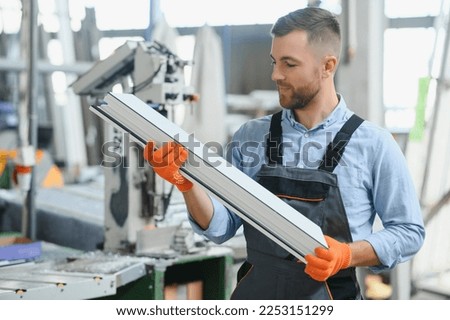 Factory for aluminum and PVC windows and doors production. Manual worker assembling PVC windows and doors. Royalty-Free Stock Photo #2253151299