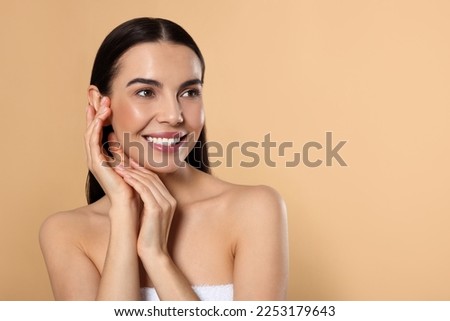 Portrait of attractive young woman on beige background, space for text. Spa treatment Royalty-Free Stock Photo #2253179643