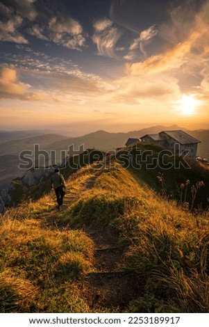 Sunrise on a mountain ,a man walking on a hiking trail towards house