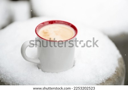 mug with coffee in the snow. winter. snowfall.