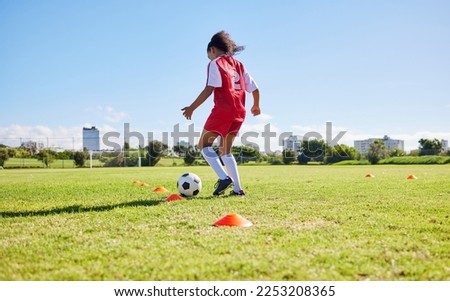 Football girl child, field and training for fitness, sports and development of balance for control, speed and strong body. Female kid, fast soccer ball dribbling or workout feet on grass for learning Royalty-Free Stock Photo #2253208365