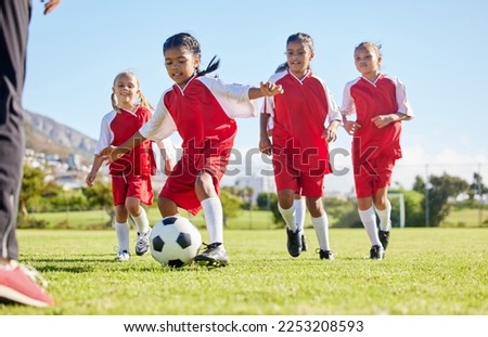 Soccer, ball or sports and a girl team training or playing together on a field for practice. Fitness, football and grass with kids running or dribbling on a pitch for competition or exercise Royalty-Free Stock Photo #2253208593