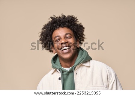 Happy joyful young African American hipster guy isolated on beige background. Smiling funny ethnic teen student, cool curly gen z fashion model laughing with dental smile white teeth, portrait. Royalty-Free Stock Photo #2253215055