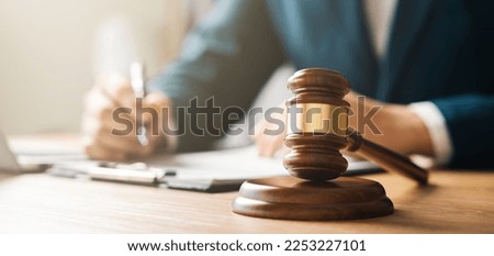 Justice concept, male judge doing report papers in courtroom, fair trial, drafting new law to modern era. Royalty-Free Stock Photo #2253227101
