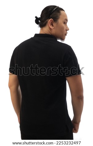Rear view of Asian man with bun hair wearing black shirt isolated cut out on white, looking to the side