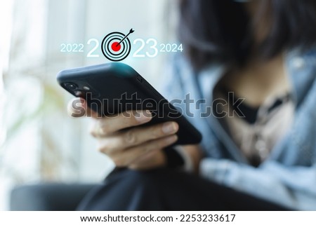 Close-up female hands using smartphone target 2023. strategy, growth success business year 2022 to 2023 and 2024.