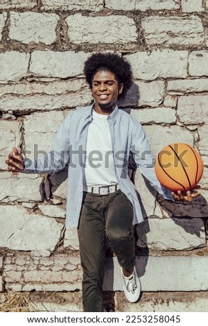 warm portrait of african american man with basket ball over wall