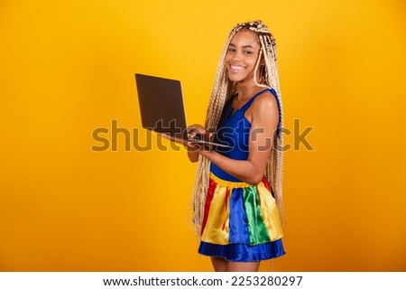 beautiful black, brazilian woman with braids, wearing clothes for carnival. Holding notebook.