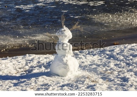 A cute snowman by the water at Big Bear Lake in California.