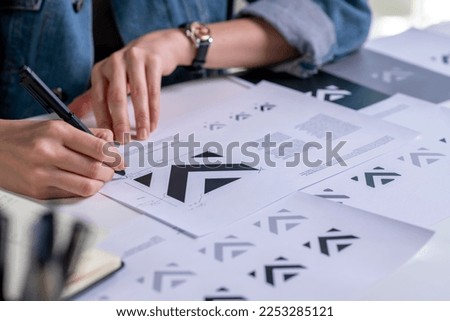 Graphic designer drawing sketches logo design. The concept of a new brand. Professional creative occupation with idea. Royalty-Free Stock Photo #2253285121