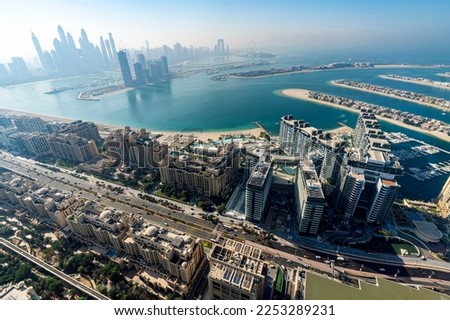The Palm island panorama with Dubai marina rising in background aerial view