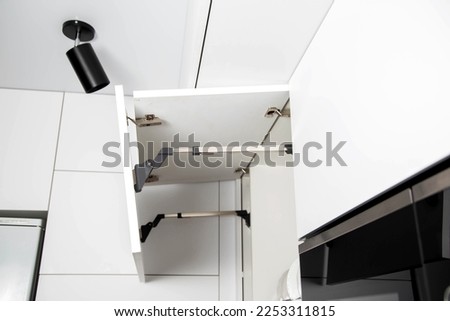 The modern lifting mechanism of a facade of a door with the closer. Furniture kitchen fittings. Ergonomics