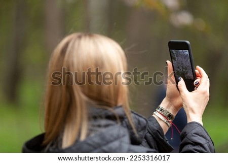 A woman takes pictures of cherry blossoms