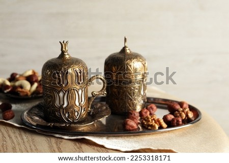 Tea and nuts served in vintage tea set on wooden table, space for text