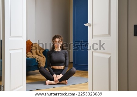 Beautiful happy girl with closed eyes having rest after practicing yoga at home Royalty-Free Stock Photo #2253323089