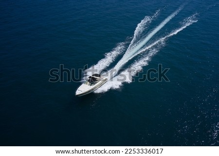 Large motor boat with an awning fast movement on dark water aerial view. Royalty-Free Stock Photo #2253336017
