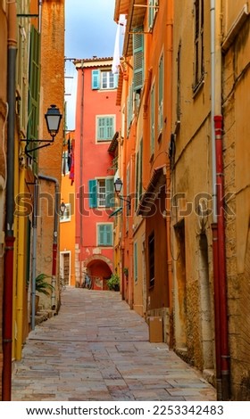 Traditional old terracotta houses on a narrow street in the Old Town of Villefranche sur Mer on the French Riviera, South of France Royalty-Free Stock Photo #2253342483