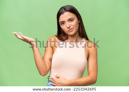 Young caucasian woman isolated on green chroma background having doubts Royalty-Free Stock Photo #2253342695