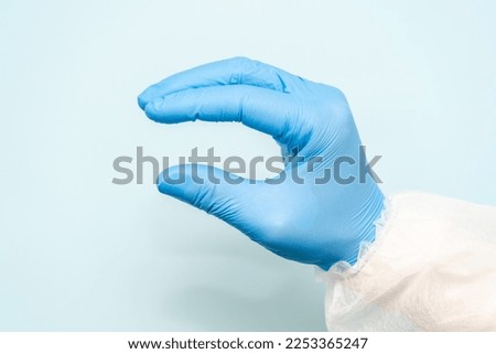 A doctor's hand in blue glove like holding something