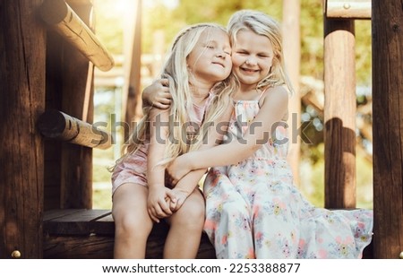 Happy, hug and girl siblings at playground for bonding, wellness and outdoor summer fun together. Care, freedom and happiness of young kids embracing with cheerful smile at park in Canada.