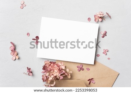 Wedding invitation or greeting card mockup with dry hydrangea flowers, top view, copy space
