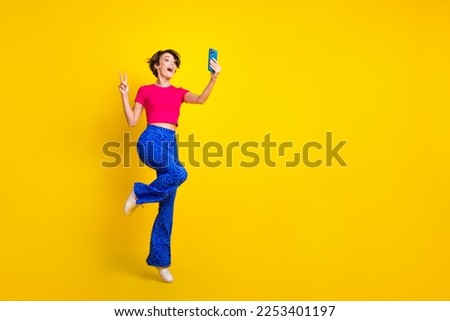 Full length photo of attractive pretty lady blogger recording video make content v-sign empty space isolated on yellow color background
