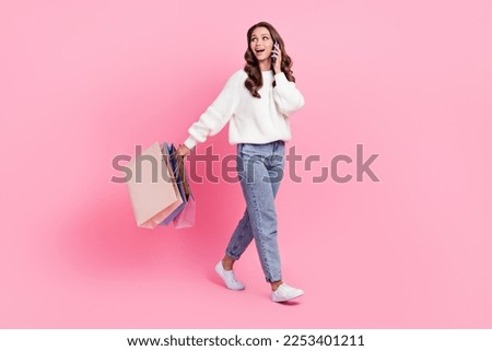 Full length photo of cute excited woman dressed white pullover talking device shopping empty space isolated pink color background