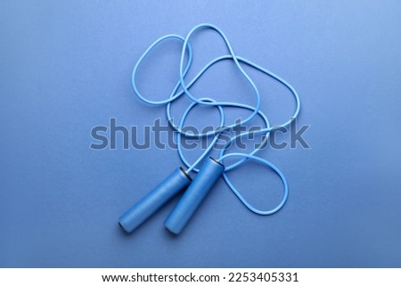 Skipping rope on blue background Royalty-Free Stock Photo #2253405331