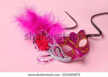 Beautiful carnival mask for Mardi Gras celebration on pink background